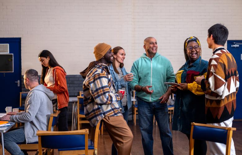 Diverse group of people standing and talking in a community hall