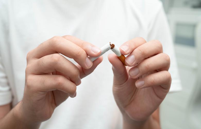 Person breaking a cigarette in two