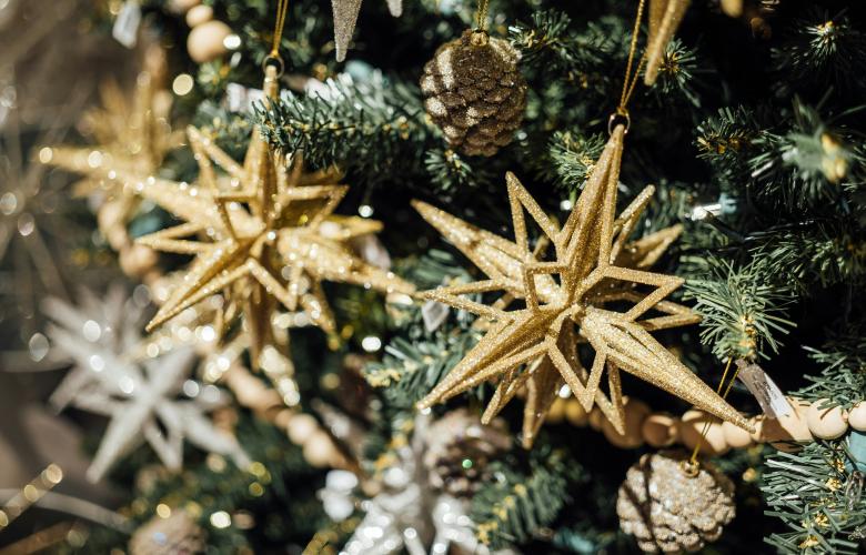 Gold stars hanging on a pine Christmas tree