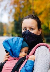 Mother wearing a face mask holding their baby